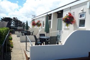 Chalet bungalows which have their own patio area, 2 small steps with handrail leading into each bungalow